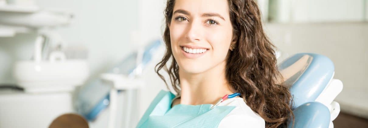 portrait-smiling-young-woman-sitting-chair-dental-clinic