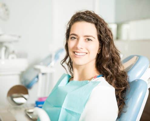 portrait-smiling-young-woman-sitting-chair-dental-clinic